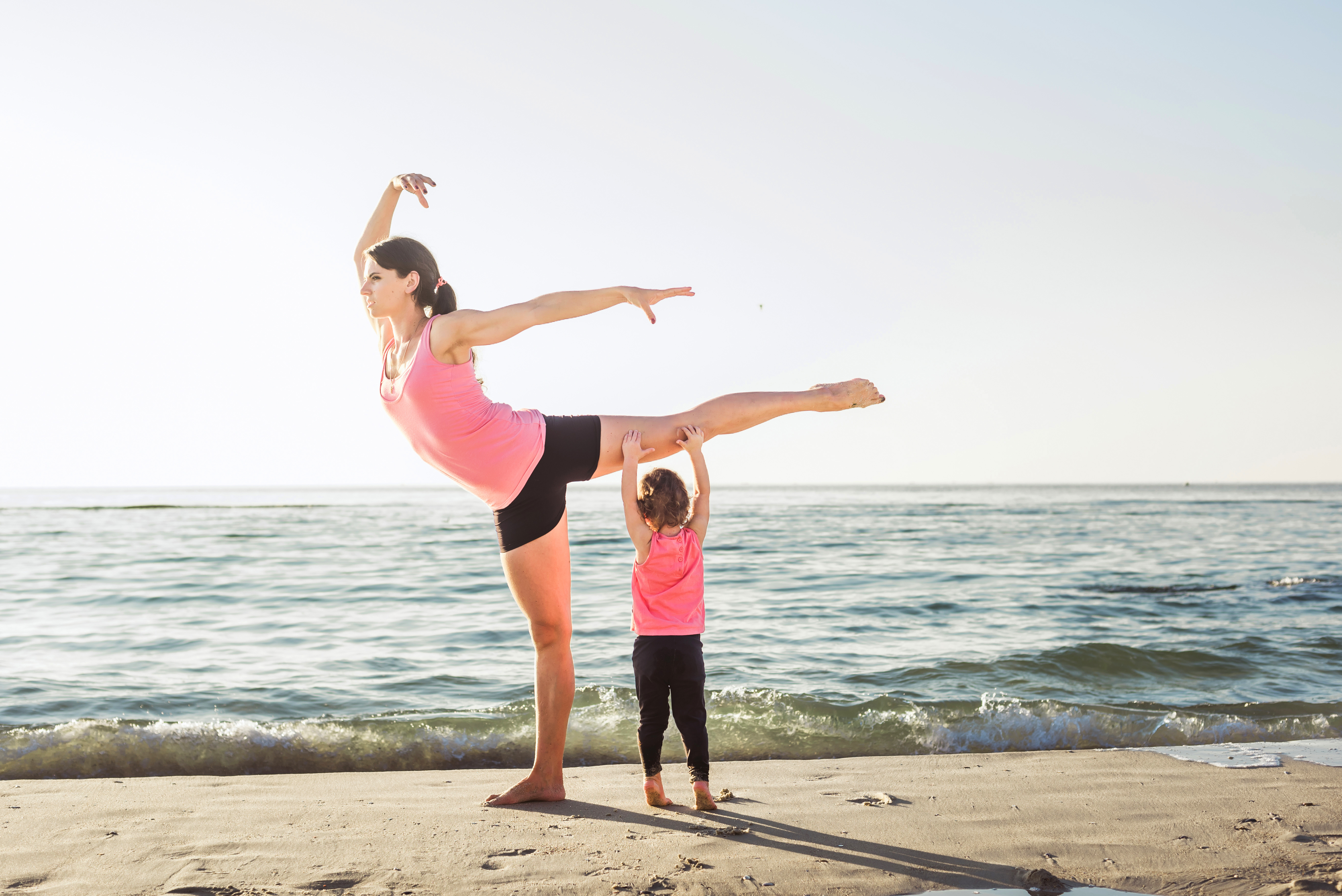 Woman Completing Yoga Exercise While Watching Children